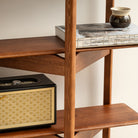Wooden shelf with a vintage-style radio and books on a neutral background