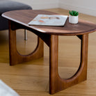 Wooden coffee table with a magazine and small plant on a wooden floor.
