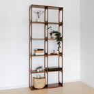 Wooden bookshelf with decorative items against a white wall
